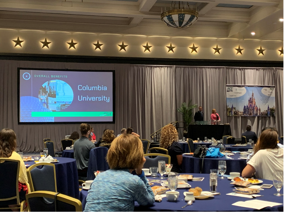 ACT Conference in Walt Disney World, Florida; a screen shows Columbia University's commuter shuttle presentation in front of a room of conference attendees.